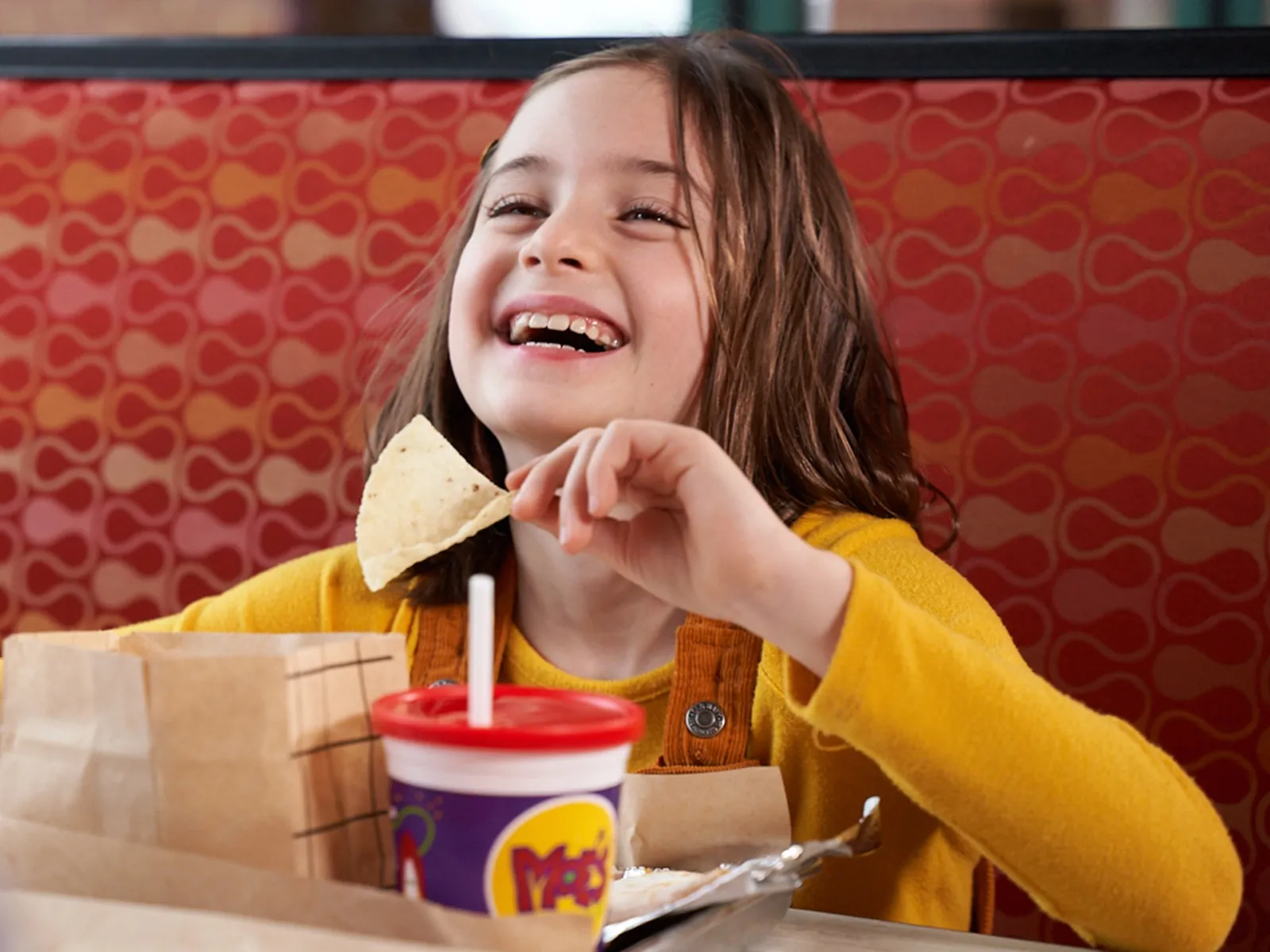Girl laughing while eating a chip at Moe's Southwest Grill